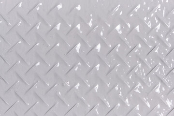Background, texture of metal with diamond shaped pattern, painted with gray paint.