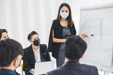 A young businesswoman presents a modern business plan to the team in the company office.