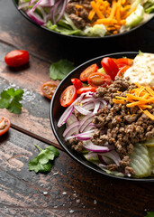Cheeseburger, hamburger or burger keto salad with beef, fresh tomatoes, red onion, pickled gherkins, lettuce and home made sauce dressing
