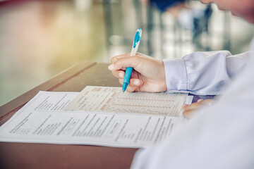 close-up of hand holding a pen and studying intently in the exam room