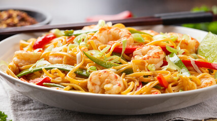 Stir fry noodles with prawns and vegetables in white plate. Healthy asian food