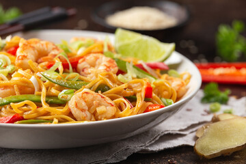 Stir fry noodles with prawns and vegetables in white plate. Healthy asian food