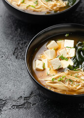 Rich miso soup with enoki mushrooms, wakame seaweed and tofu, vegetarian, vegan Asian food.