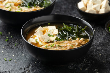 Rich miso soup with enoki mushrooms, wakame seaweed and tofu, vegetarian, vegan Asian food.