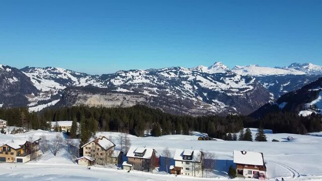 Ski resort Stoos in the Swiss Alps, air survey mountain peaks, and rocks covered with snow and blue sky in winter. Stoos, Schwyz, Switzerland.