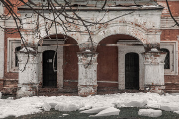 A beautiful old building. Red brick facade. Old beautiful architecture. Winter day. Cloudy weather. Snowy winter day.