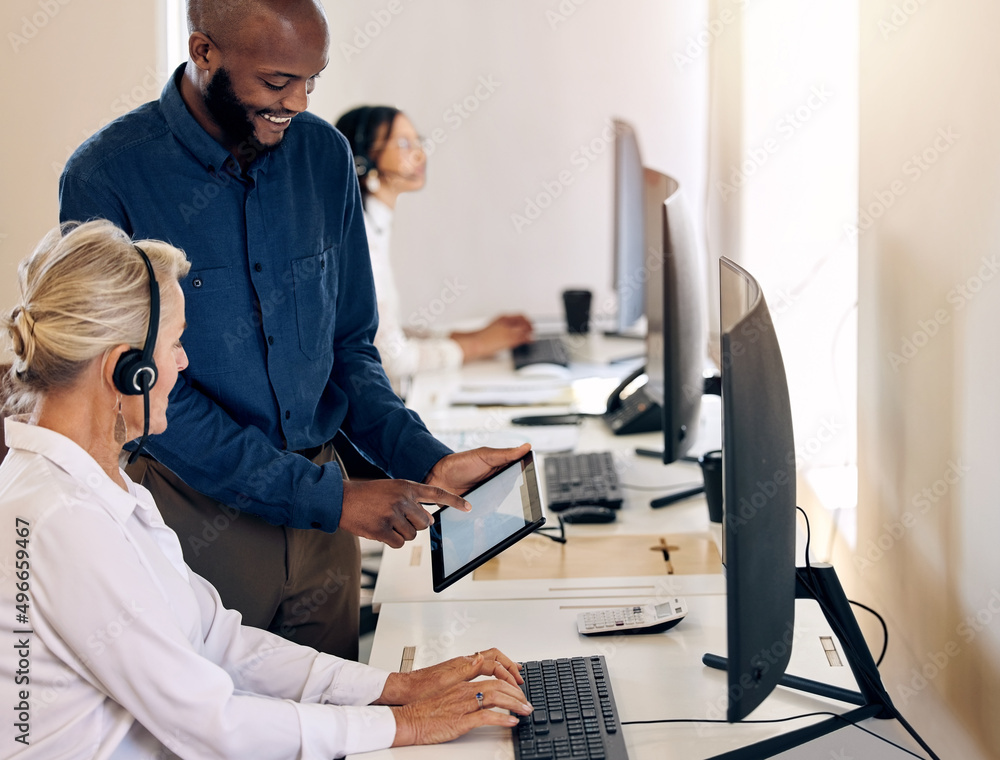 Poster Simplifying processes to the right solutions. Shot of two call centre agents working together on a digital tablet in an office.