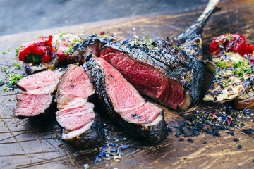 Modern style barbecue dry aged angus tomahawk steak with grilled vegetable served as close-up on an...