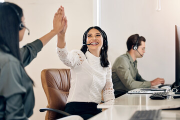 Heres to making all the big sales today. Shot of a young call centre agent giving her colleague a high five in an office. - obrazy, fototapety, plakaty