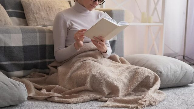 Reading leisure. Cozy weekend. Hygge lifestyle. Dreamy calm woman enjoying interesting book story on floor relaxing at home living room.