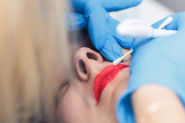 woman making permanent makeup in cosmetology salon.lip contour drawing