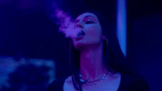 Close-up of a girl in a club, dancing and smoking an electronic cigarette. Night club