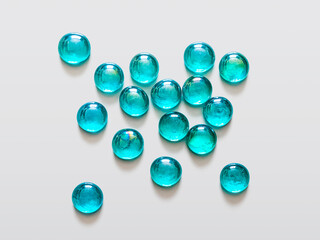 Transparent glass beads of delicate turquoise color on a light background