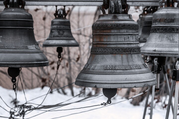 Obraz premium Ancient metal bells. Religious church bells. Rusty old bells. Winter gray snowy day.
