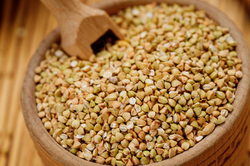 Obraz premium Buckwheat groats in bowls and bags on a wooden background. High quality photo