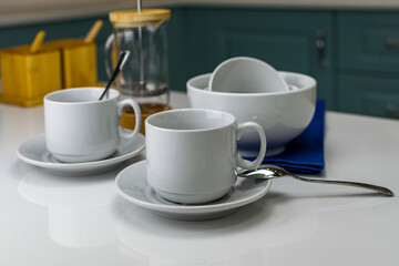 White tea cups on a white table and a blue napkin