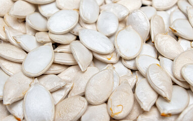 White pumpkin seeds as background.