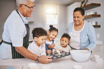 Filling trays halfway, the right way. Shot of a mature couple baking with their grandkids at home.