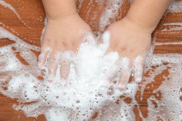 Fototapeta premium The boy plays with soap suds