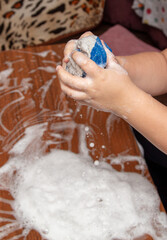 Boy wipes the table with soapy foam