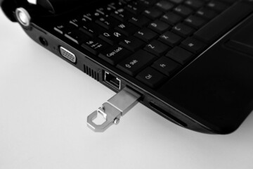Technology concept part of laptop and flash drive, close-up