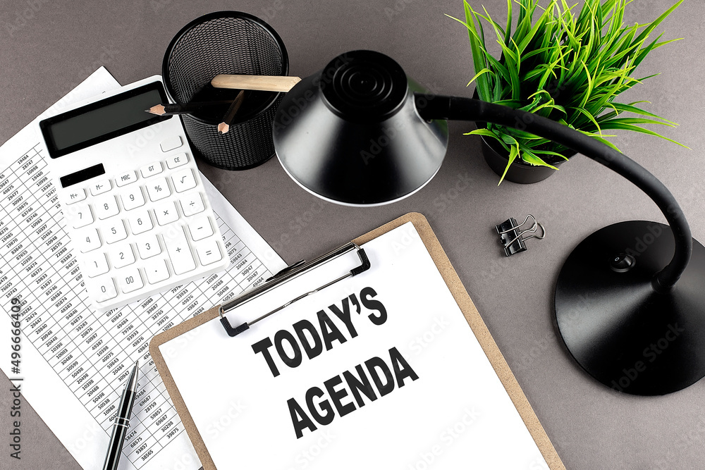 Poster clipboard ,chart and calculator, lamp and workspace accessories on a grey table. top view , text tod