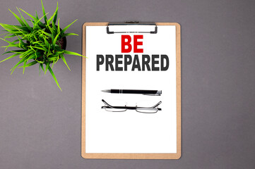 BE PREPARED, on the brown clipboard on the grey background. Business concept