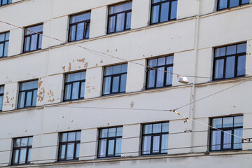 The wall of a multi-storey house is cracked, the plaster is crumbling