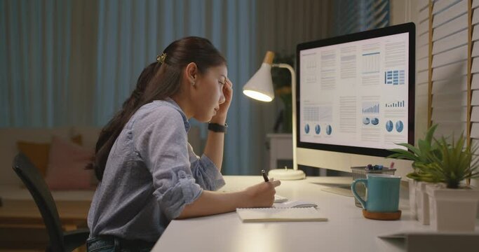 Asia people young woman study hard overnight brownout bored remote learn online read data tired sitting head in hands at home office desk workplace think worry in job tough stress workforce issue.
