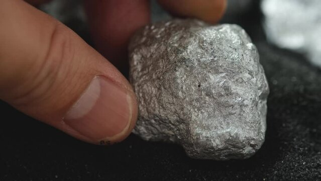 Miners hold in their hands platinum or silver or rare earth minerals found in the mine for inspection and consideration	