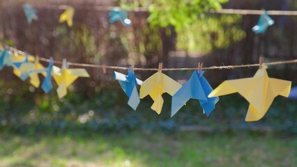 Blue and Yellow Origami Paper Peace Doves Decoration Hanging in Park as Sign of Support to Ukraine during War with Russia after Invasion