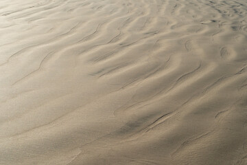 Sand texture waves close up. Abstract background pattern of wet sand beach. - obrazy, fototapety, plakaty