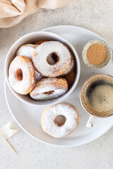 Traditional breakfast of a doughnut with sugar and milk or coffee on a white background. Selective focus.