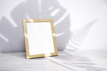 Mock up wood poster frame,shadows branch leaves on a white wall