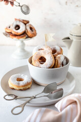 Fresh homemade fried donuts covered with powdered sugar on a white background. Selective focus.
