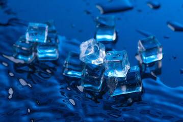 Ice cubes with water drops scattered on a blue background