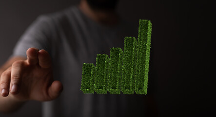 Businessman hand holding step of coins stacks with tree growing on top in nature green background....