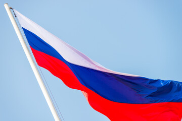Russia flag is waving in front of blue sky