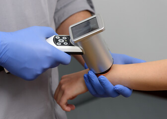 Digital dermatoscopy of moles. A dermatologist-oncologist examines the patient's moles using a...