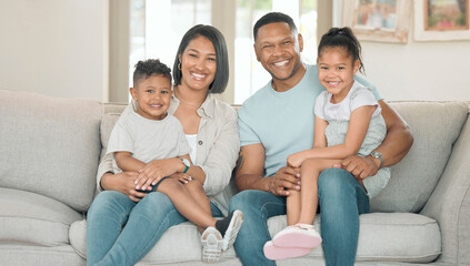 Were a happy family in a happy home. Shot of a young couple sitting on their sofa at home with their children.