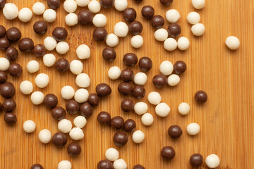 white and black chocolate balls on wooden table