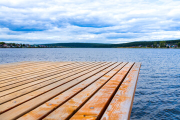 pier on the lake empty without objects, summer cloudy day