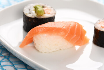 Sushi and rolls on a white plate.