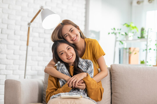 An Asian couple is taking care to their partner. LGBTQ female lasbian give their partner a scarf while the other has reading a book. They are living spending time together.Good moment of LGBTQ