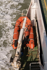 UK. 2022. Overview of a life saving boat suspended from a crane on deck of ferry.