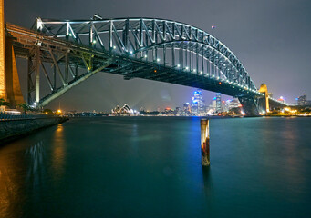 Naklejka na ściany i meble The Iconic Sydney Harbour Bridge with the Sydney Opera house illuminated at night