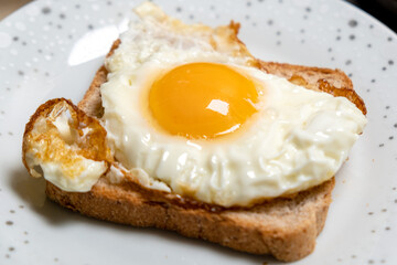 Toast sandwich with fried egg on a plate. Light, quick snack.