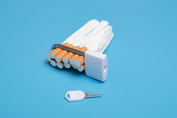 Quit smoking concept. Cigarettes squeezed into a lock on a blue background. Bad limiting habit.