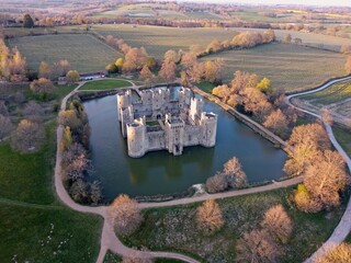Aerial drone view of Bodiam Castle, 14th-century medieval fortress with moat and soaring towers in Robertsbridge, East Sussex, England.
