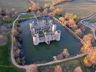 Aerial drone view of Bodiam Castle, 14th-century medieval fortress with moat and soaring towers in Robertsbridge, East Sussex, England.
